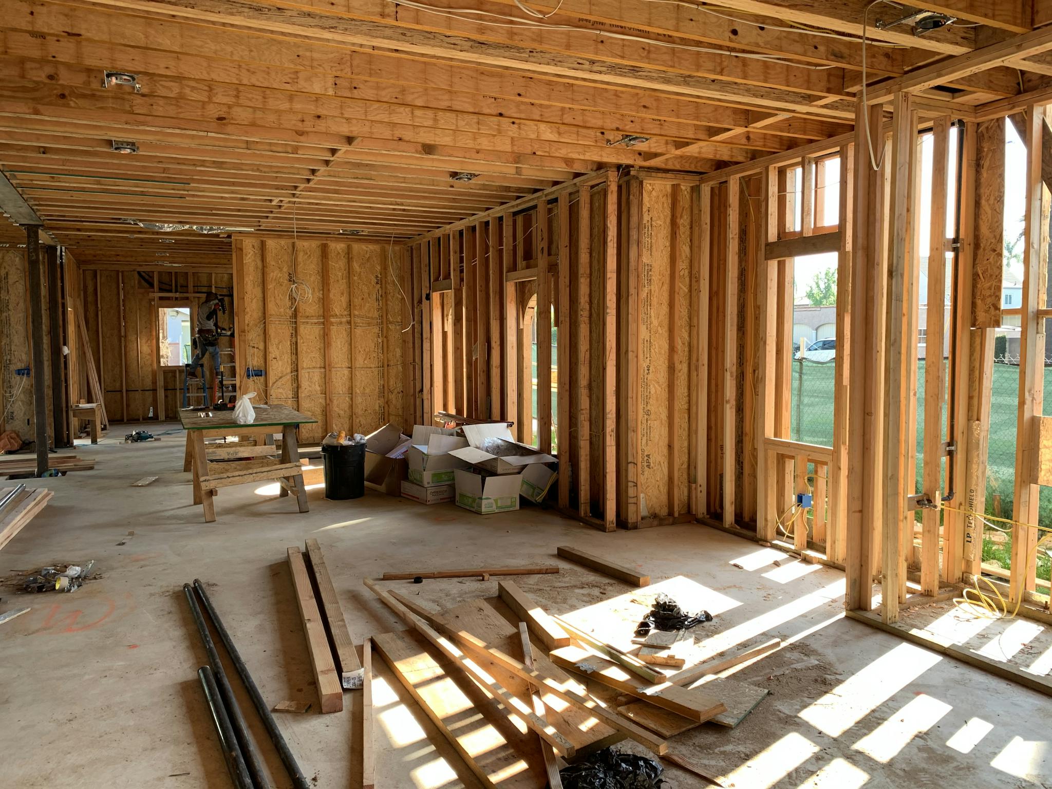 Sunlit interior with wood framing, showcasing home construction progress.